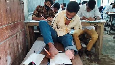 হাত নেই, এক পা দিয়ে লিখে এসএসসি পরীক্ষা দিচ্ছে মানিক